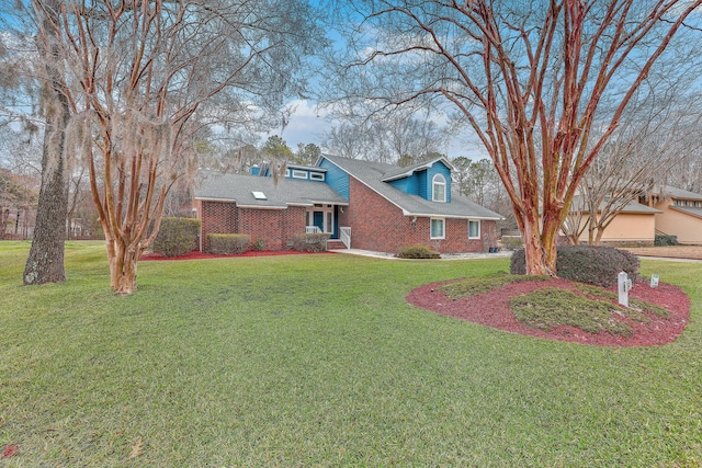 view of front facade with a front yard and brick siding