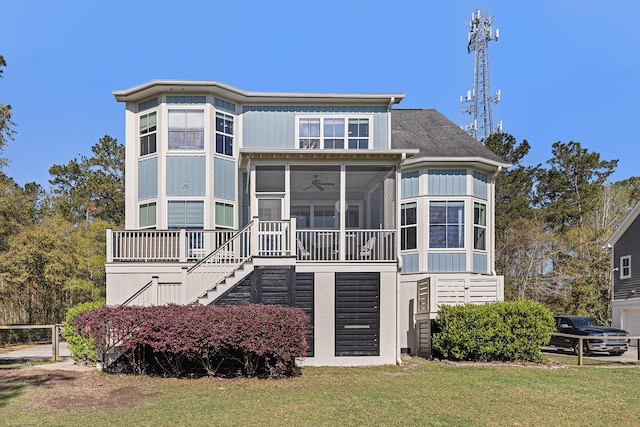 view of front of property with ceiling fan, a sunroom, and a front yard