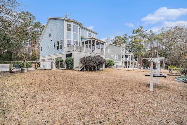 rear view of property with a sunroom and a pergola