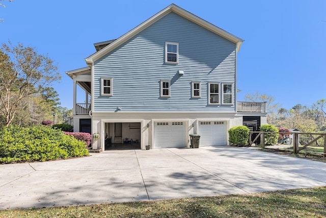 rear view of house with a garage and a balcony