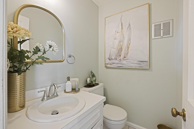 half bathroom featuring toilet, vanity, and visible vents