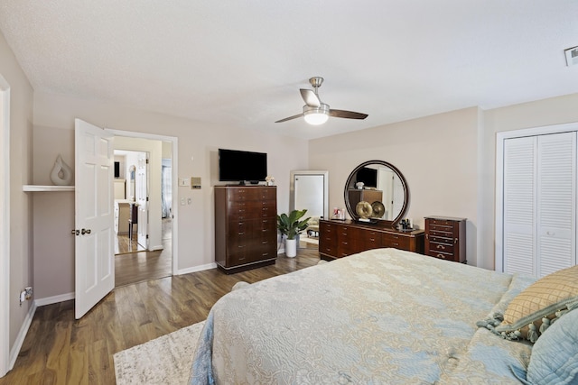bedroom featuring visible vents, a closet, baseboards, a ceiling fan, and wood finished floors