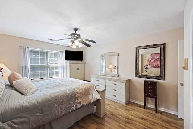 bedroom featuring baseboards, ceiling fan, and wood finished floors