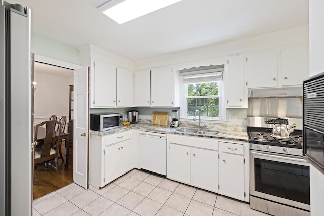kitchen with a sink, white cabinets, under cabinet range hood, and stainless steel appliances