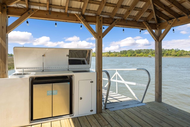 dock area with a water view and exterior kitchen