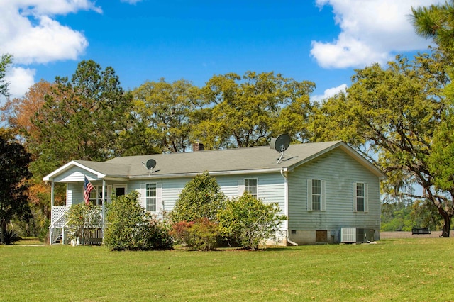 back of property featuring a yard, a chimney, and central air condition unit