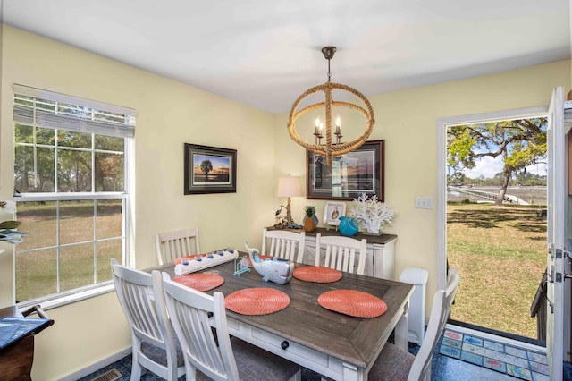 dining area featuring a chandelier and baseboards