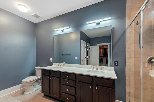 bathroom with tile patterned flooring, a shower with door, toilet, and vanity