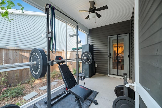 workout area featuring wooden walls, ceiling fan, and a wealth of natural light