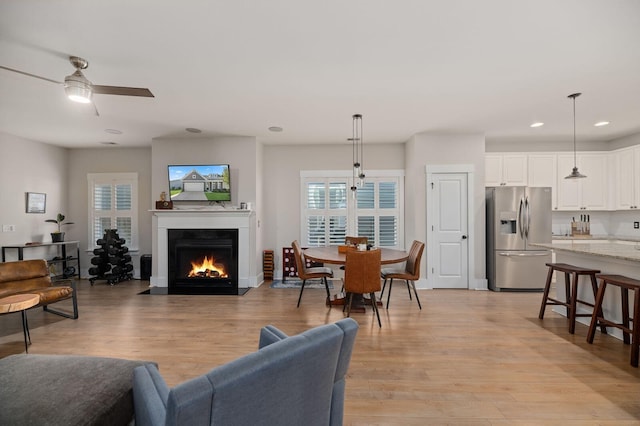 living room featuring light wood-type flooring and ceiling fan