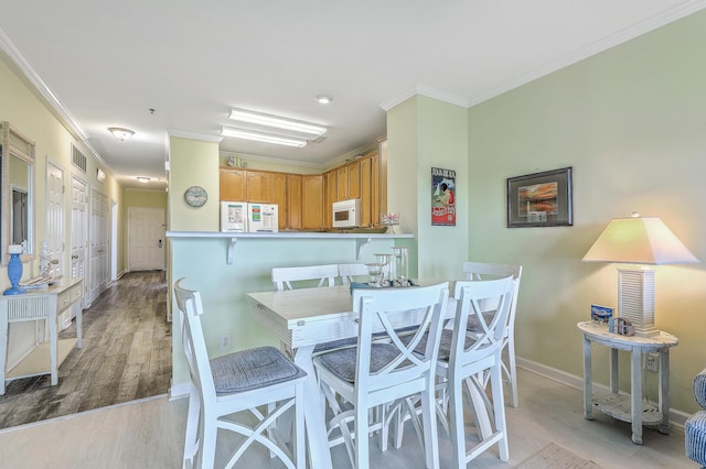 2393 Folly Rd Unit 1G, Folly Beach, SC 29439 - dining room featuring light wood finished floors, crown molding, and baseboards