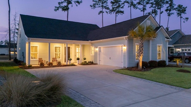 new england style home with a garage, concrete driveway, a porch, and a lawn