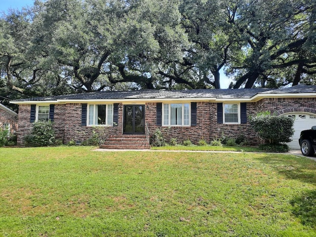 ranch-style house featuring a garage, brick siding, and a front lawn