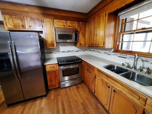 kitchen featuring a sink, light countertops, brown cabinets, and stainless steel appliances