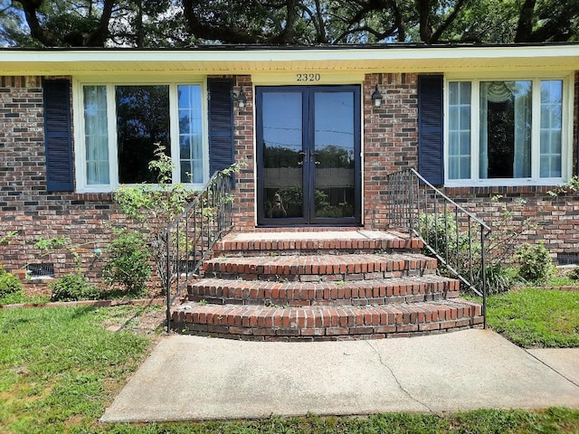 property entrance featuring brick siding and french doors