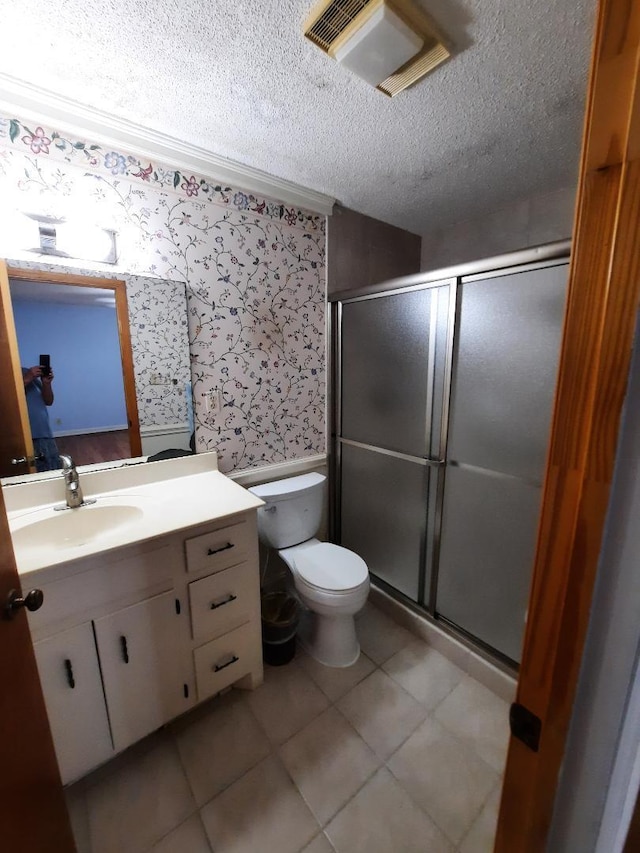 full bath with visible vents, wallpapered walls, toilet, a stall shower, and a textured ceiling