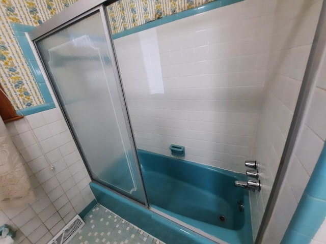 full bath with visible vents, shower / bath combination with glass door, tile walls, and wallpapered walls