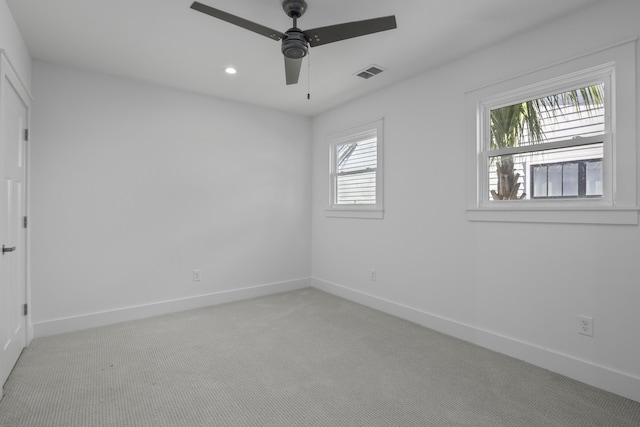 carpeted spare room featuring ceiling fan