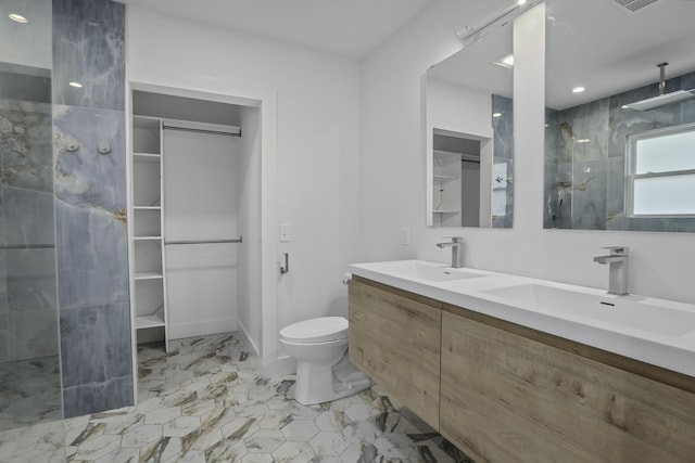 bathroom with toilet, vanity, and tiled shower