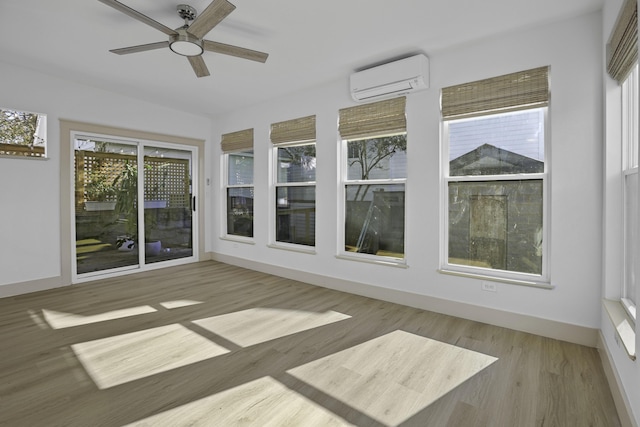 unfurnished sunroom with ceiling fan and a wall unit AC