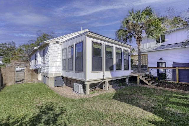 view of side of home with a sunroom and a yard