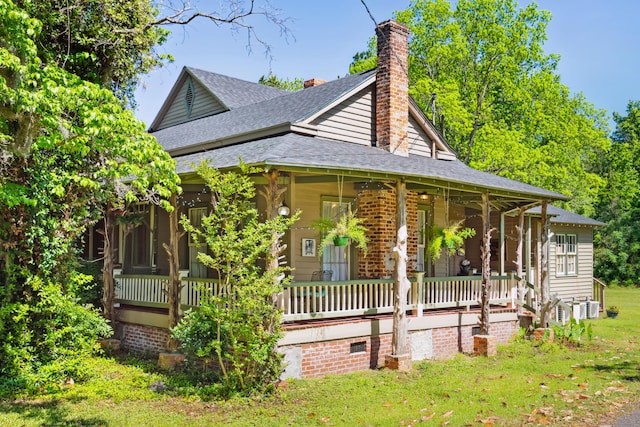 view of side of home with central AC unit, a porch, and a lawn