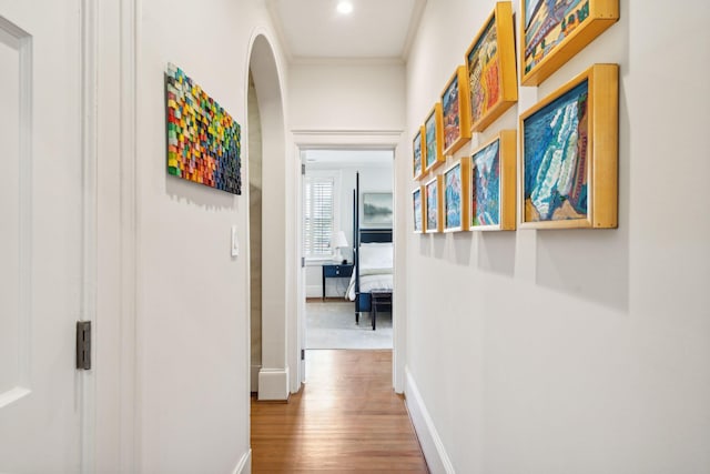 hallway featuring hardwood / wood-style floors and ornamental molding