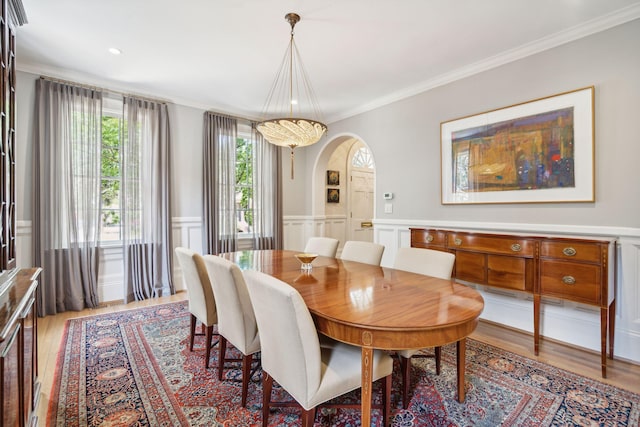 dining space featuring light wood-type flooring and ornamental molding