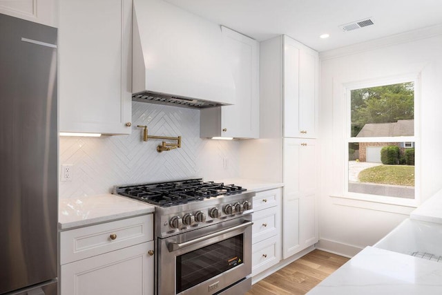 1199 Island View Dr, Mount Pleasant, SC 29464 - kitchen featuring white cabinetry, visible vents, appliances with stainless steel finishes, tasteful backsplash, and custom exhaust hood