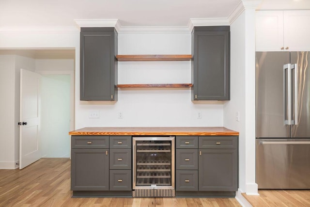 1199 Island View Dr, Mount Pleasant, SC 29464 - bar featuring freestanding refrigerator, beverage cooler, light wood-style flooring, and ornamental molding