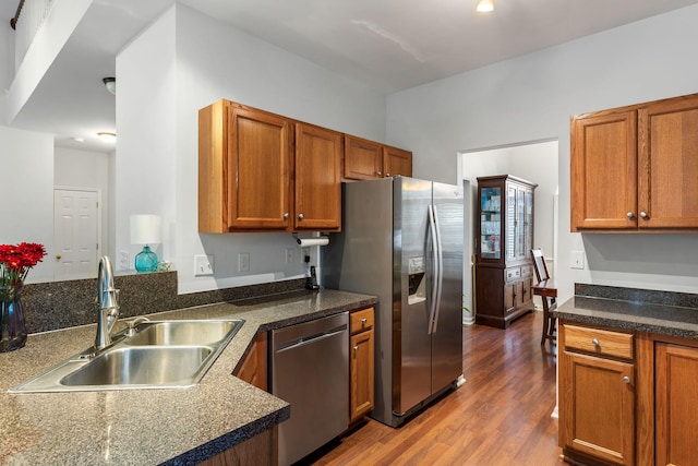 kitchen featuring kitchen peninsula, sink, dark wood-type flooring, and appliances with stainless steel finishes