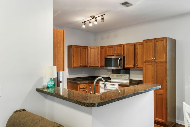 kitchen featuring kitchen peninsula, sink, and white electric range