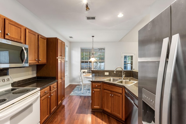 kitchen featuring sink, pendant lighting, dark hardwood / wood-style floors, and appliances with stainless steel finishes