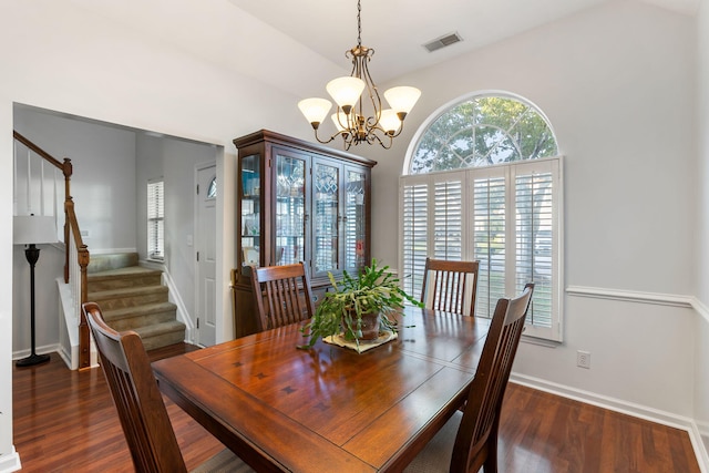 dining area featuring dark hardwood / wood-style floors and an inviting chandelier