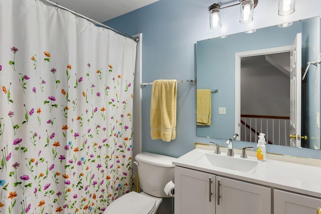 bathroom with a shower with shower curtain, vanity, and toilet