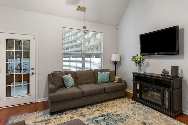 living room with dark wood-type flooring and vaulted ceiling