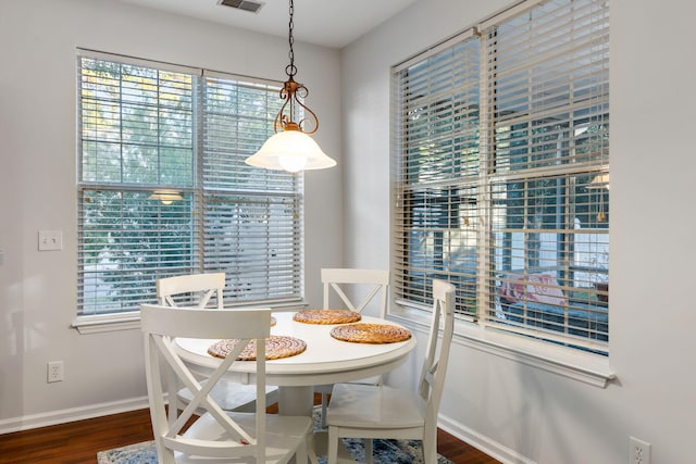 dining room featuring dark hardwood / wood-style flooring and a healthy amount of sunlight