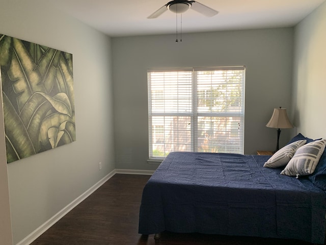 bedroom with a ceiling fan, baseboards, and dark wood-style flooring