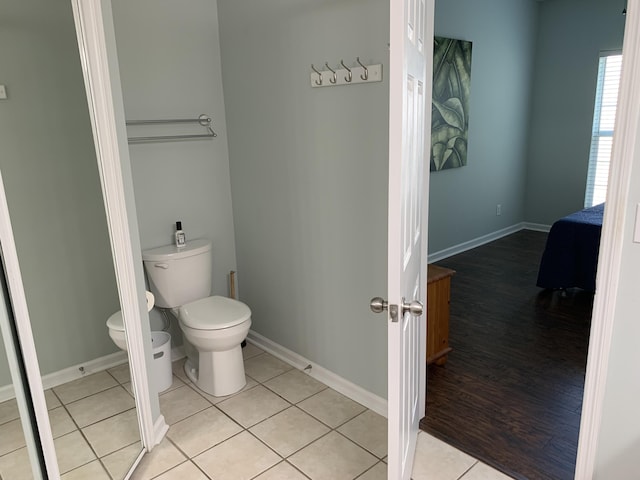 bathroom featuring tile patterned flooring, toilet, and baseboards