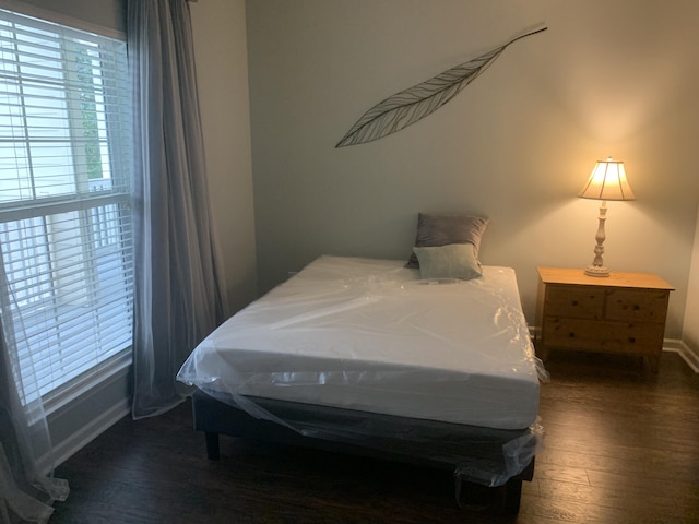 bedroom featuring wood finished floors and baseboards