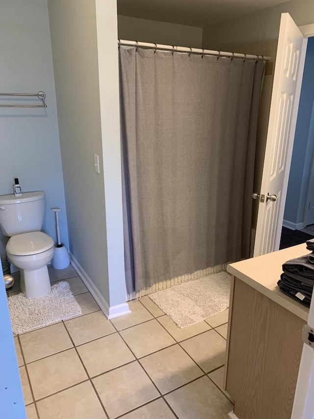 full bathroom featuring tile patterned flooring, toilet, a shower with curtain, and baseboards