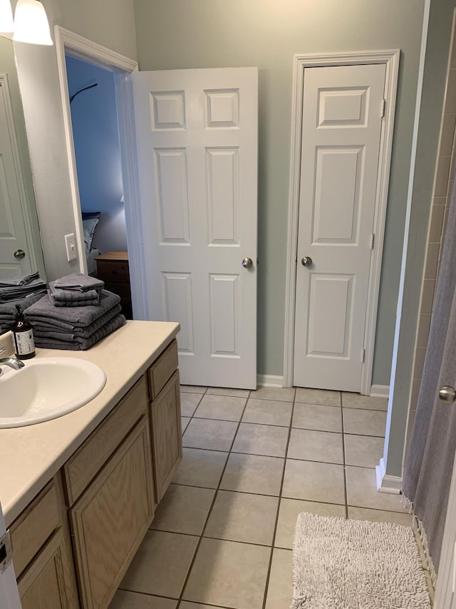 full bath with tile patterned floors, vanity, and baseboards