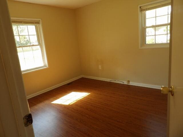 unfurnished room featuring dark wood-type flooring