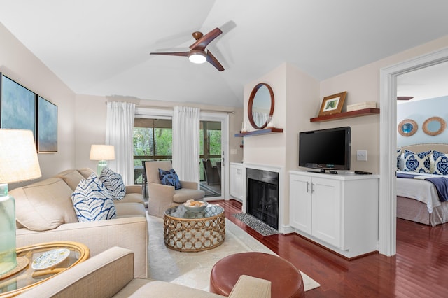 living room featuring ceiling fan, vaulted ceiling, and dark wood-type flooring