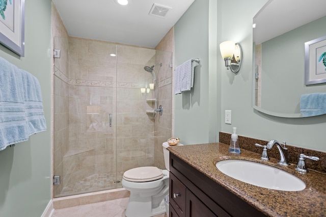 bathroom featuring toilet, a shower with door, vanity, and tile patterned flooring