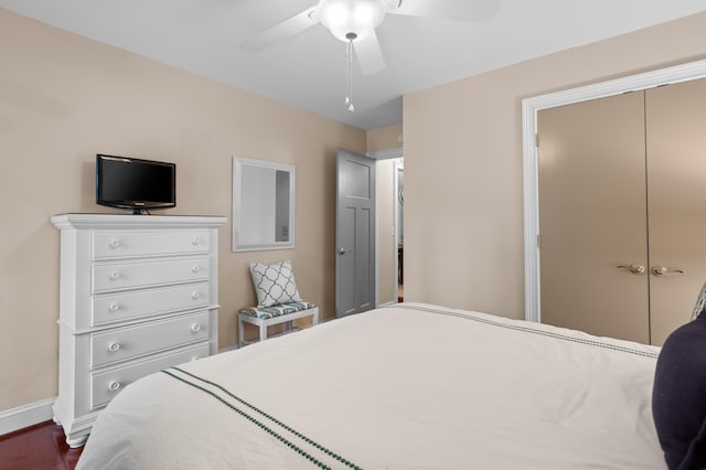 bedroom with ceiling fan, dark hardwood / wood-style flooring, and a closet