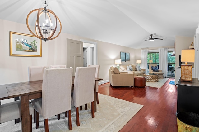 dining area featuring dark wood-type flooring, lofted ceiling, and ceiling fan with notable chandelier