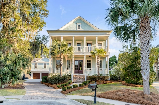 view of front of home with a garage, covered porch, decorative driveway, and a balcony