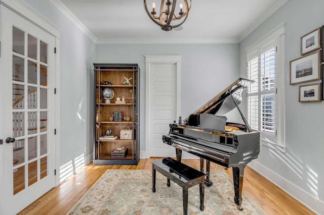 sitting room with ornamental molding and wood finished floors