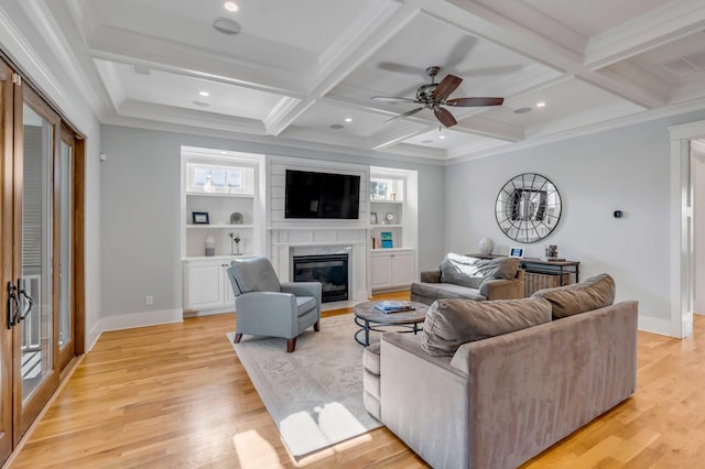 living room featuring beam ceiling, coffered ceiling, light wood-style flooring, and a high end fireplace